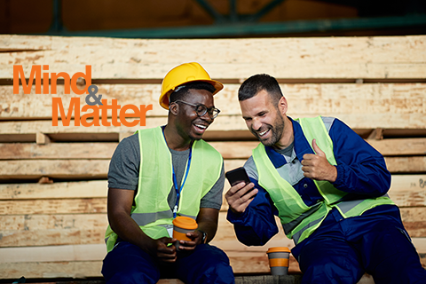 Two co-workers sitting on their break having a cup of coffee together.