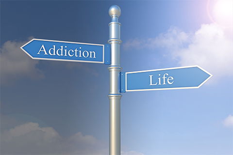 Image of a sign post with two arrows pointing in opposite directions "Addiction" and "Life"