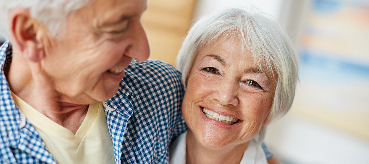 Image of an elderly couple happily embracing