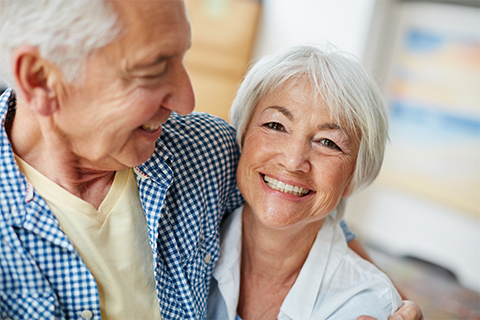 Image of an elderly couple happily embracing